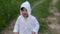 Caucasian child boy in a white sweater with a hood dancing on the road