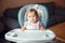 Caucasian child girl sitting in high chair ready to eat