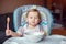 Caucasian child kid girl sitting in high chair eating cereal with spoon