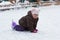 Caucasian child of three years old on knees after falling down on the rink with skates on legs in wintertime