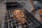 Caucasian close-up hands cooking beef steak on the grill net on coal bbq outdoors. Back yard bbq party in summer or