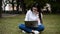 Caucasian college girl busy using laptop in the lawn in campus