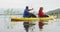 Caucasian couple having a good time on a trip to the mountains, kayaking together on a lake