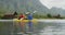 Caucasian couple having a good time on a trip to the mountains, kayaking together on a lake
