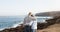 Caucasian couple of people with gray hair standing on the cliff of the ocean. Morning soon outdoor with clear sky. Vacation and