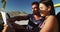 Caucasian couple sitting in beach buggy by the sea reading a map