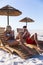 Caucasian couple sitting on deck chairs at the beach