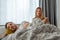 Caucasian couple with suspicious wife checking husband\'s phone while he is sleeping