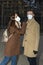 Caucasian couple wearing masks and black nitrile gloves walking on street