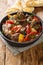 Caucasian cuisine Buglama lamb stewed with vegetables and herbs close-up in a bowl. vertical