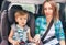 Caucasian cute son and mother are buckled with safety belt in a