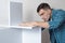 Caucasian dark haired man thoroughly assembling furniture