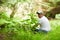 A caucasian disability man resting in the bright green fresh forest.