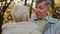 Caucasian elderly middle-aged woman grandma meet embracing senior husband pensioner grandpa in autumn park lovely old