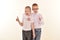 A caucasian elementary age boy with glasses posing in uniform isolated on white background with him brother. School and education