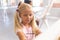 Caucasian elementary schoolgirl painting on easel during drawing class in school