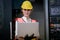 Caucasian factory worker woman hold laptop and smile also look to camera in workplace area in front of digital machine. Concept of