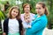 Caucasian family portrait with adult mother with newborn son and his teen age sister, grandmother stands behind