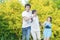 Caucasian Family of Three Having Fun Together and Running in Summer Forest With Joined Hands Outdoors