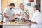 Caucasian family three man people cook together lokking the how to do on the mobile phone of the mother. everybody have fun and