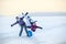 Caucasian family from three women standing with raising hands on lake, winter hiking