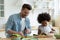 Caucasian father and ethnic daughter cooking in kitchen