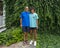 Caucasian father and his Amerasian teenage son posing for a photo in front of a dense wall of ivy in Bar Harbor, Maine.