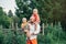 Caucasian father hugging playing with sons boys in park on summer day. Dad holding carrying children kids.