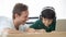 Caucasian father teaching half-race son to do homework. Idea for dad and kid mixed-race