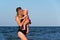 Caucasian female baby first time at sea, jump into water and have fun