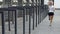 Caucasian female exercising next to security turnstiles, street workout session