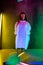 Caucasian female inclusive model posing on studio background in neon light