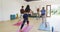 Caucasian female instructor demonstrating yoga poses to diverse group at yoga class