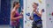 Caucasian female instructor showing woman how to knot a rope at indoor climbing wall