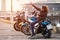 Caucasian female motorcyclist sitting on motorbike and getting a selfie with mobile phone