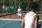 Caucasian female player serving tennis ball to competitor at court on sunny day