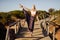 Caucasian female practicing yoga on wooden bridge.