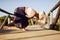 Caucasian female practicing yoga on wooden bridge.