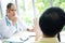 Caucasian Female Psychiatrist or neurologist is counseling and listening to patient problems for treatment asian man in clinic.