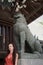 Caucasian female tourist snarling with white marble dragon lion statue in Japan