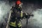 Caucasian fireman in uniform stand in smoke