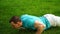 Caucasian fitness man training push up exercising in grass. male athlete working outdoor