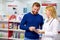 Caucasian friendly pharmacist has a nice conversation with a client, helps to find a medication