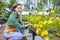 Caucasian garden owner is tending to her ornamental flower plant at nursery garden center for native and exotic plant grower