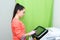 Caucasian girl beautician adjusts the device for hair removal with a laser. Cosmetic equipment device.