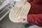 Caucasian girl buys wooden, wicker bread dishes with wooden tongs in a store