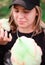 Caucasian girl in cap tears off pieces and eats candy-floss. Texture of multicolored candy-floss. Happy teenage girl enjoys sweets