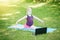 Caucasian girl child in face mask doing sport workout outdoor online. Video yoga stretching on Internet. Kid learning training on