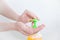 Caucasian girl clicks  dispenser with soap. Close-up, white background