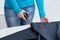 Caucasian girl cuts black cloth on the table. In room. Close-up